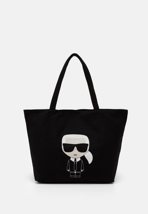 Sac cabas noir avec deux poignées et un personnage de dessin animé portant des lunettes de soleil et un costume imprimé sur le devant.