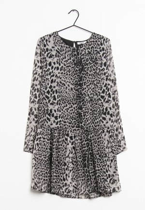 Sukienka z długim rękawem w panterkę, z okrągłym dekoltem, talią zebrana i lekko rozkloszowaną spódnicą, wisząca na czarnym wieszaku.