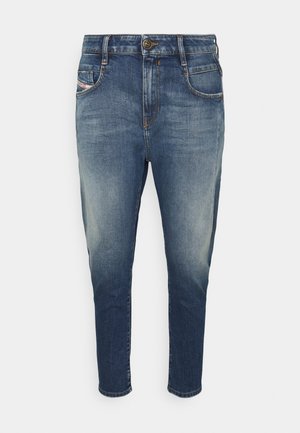 Tummansiniset farkut, joissa haalistunut efekti. Niissä on viisi taskua, oranssinvärinen kontrastitikkaus ja nappikiinnitys vyötäröllä.