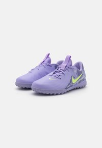 Lilla sportssko med en glat syntetisk overdel, tekstureret sål og neongul accent. Har en rund tå og snørrelukning.