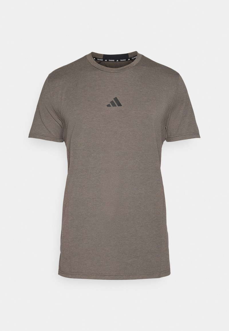 Camiseta marrón de manga corta hecha de tela suave, con un logo negro de Adidas en el pecho y un cuello redondo con acentos de logo.