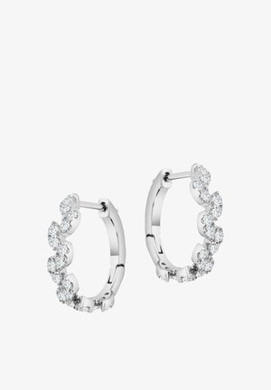 Srebrne kolczyki w kształcie obręczy z zaokrąglonym designem, zdobione wieloma małymi okrągłymi przezroczystymi kamieniami ułożonymi w falisty wzór wzdłuż przedniej krawędzi.