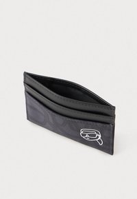 Juodas piniginės su tekstūruotu audinio išoriniu paviršiumi, papuoštas balta logo. Su multiple kortelių vietomis organizavimui.
