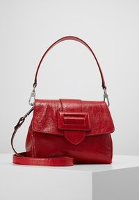 Sac à main en cuir rouge avec une finition texturée, un rabat rectangulaire, une grande boucle rectangulaire et une bandoulière réglable.