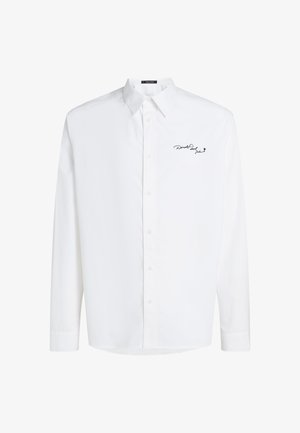 Camicia bianca a maniche lunghe con bottoni, realizzata in cotone, dotata di colletto a punte e logo ricamato nero sul lato sinistro del petto. Texture liscia.