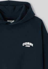 Sweat à capuche bleu marine en coton, avec une poche avant et un logo brodé "CORGIs club" en blanc sur la poitrine.