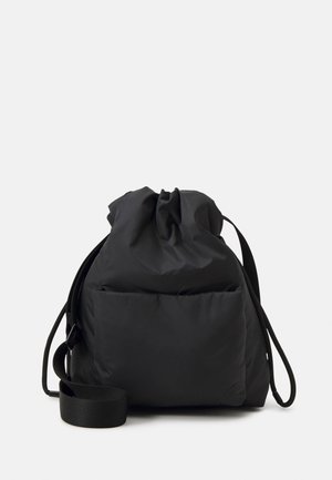 Czarna nylonowa torba ściągana sznurkiem z miękką, wyściełaną teksturą, wyposażona w pojedynczy pasek i dwie przednie kieszenie do przechowywania.
