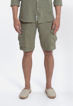 Linnen overhemd en cargoshorts in olijfgroen, met patchzakken. Beige gestreepte espadrilles met een geweven zool. Strakke en casual pasvorm.