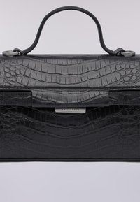 Černá kožená kabelka s texturovaným krokodýlím vzorem, strukturovaným tvarem a horním uchopovacím madlem se stříbrnými detaily a logem.