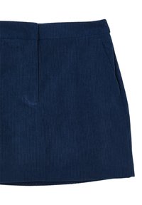 Jupe en tissu côtelé bleu marine avec un détail de couture sur le devant et des poches latérales, présentée sur un fond blanc.