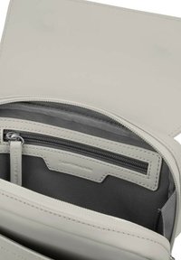 Grå läderväska inuti med dragkedjefack och flera fack; har en slät yta och subtil branding.