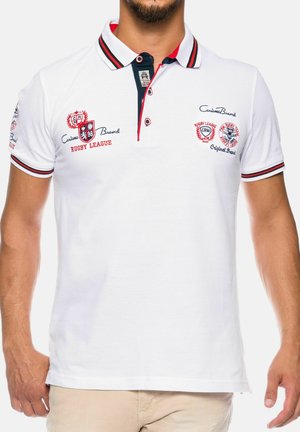 Wit poloshirt met rood-zwarte gestreepte kraag en mouwranden, met geborduurde rugby league-logo's en tekst op de borst en mouwen.