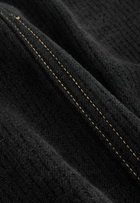 Czarna tkanina o teksturowanej powierzchni i diagonalnym wzorze; posiada kontrastujące żółte przeszycie wzdłuż szwu.