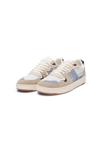 Sneaker aus einer Kombination von beigem Wildleder, weißem Mesh und blauen Akzenten. Schnürdesign und Gummisohle mit einem Logo an der Seite.