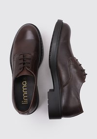 Chaussures en cuir brun à lacets avec un bout arrondi, des coutures tonales et une semelle en caoutchouc noir épaisse. Présentent une finition lisse et un design classique.