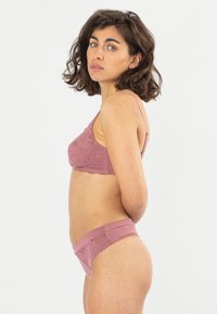 Spitzen-Bralette und passende Unterhose in sanftem Rosaton, mit filigranen Blumenmustern, verstellbaren Trägern und einem nahtlosen Bund für optimalen Komfort.