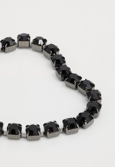 Collier en pierres précieuses noires avec des pierres taillées en octogone, montées sur un métal gris. Le design comprend des facettes alternées et une finition lisse.