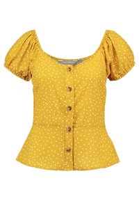 Blusa gialla a pois con maniche corte a palloncino, scollatura rotonda, chiusura a bottoni e vita peplum. Realizzata in tessuto leggero con finitura testurizzata.