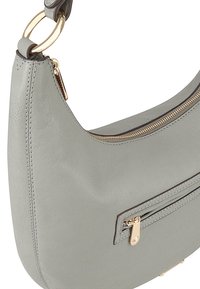 Sac à épaule en cuir gris avec une forme courbée, accents en matériel doré, fermeture zippée en haut et poche externe. Texture lisse et détails en couture.