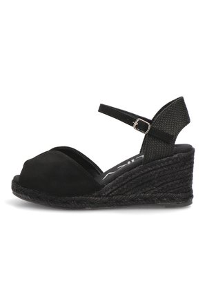 Sandalia cuña negra con puntera cerrada, correa en el tobillo con hebilla y suela plataforma texturizada trenzada.