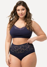 Set di bralette e slip a vita alta con bordi in pizzo di colore blu navy. Tessuto morbido con bordi scallop e dettagli in pizzo floreale sulla vita.
