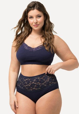 Navyblauwe bralette met kantafwerking en een set met hoge taille slip. Zachte stof met gegolfde randen en bloem-kantaccenten op de tailleband.