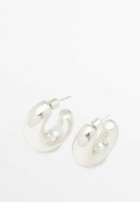 Boucles d'oreilles en argent avec un design lisse et arrondi, présentant une forme en U unique et une fermeture à tige. Fini métallique poli.