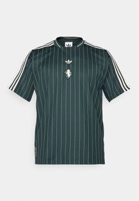 Grønstribet kortærmet skjorte med rund hals. Har et hvidt adidas-logo og en løve-patch i midten. Lavet af glat, letvægtsstof.