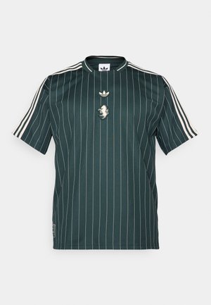 Grønstribet kortærmet skjorte med rund hals. Har et hvidt adidas-logo og en løve-patch i midten. Lavet af glat, letvægtsstof.