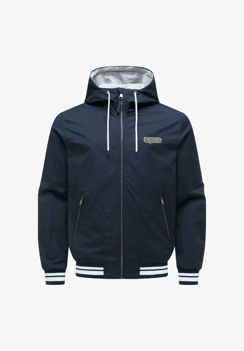 Granatowa kurtka z kapturem, zapinana na zamek z przodu, z białymi sznurkami, dwoma kieszeniami zamykanymi na zamek, paskowanymi mankietami i dołem oraz logo "ragwear" na piersi.