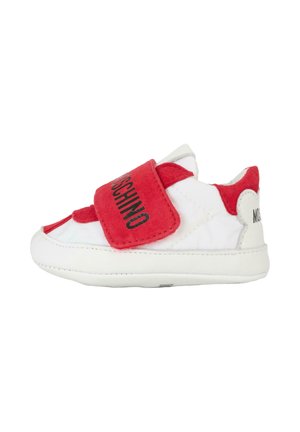 Rode en witte sneaker met een klittenbandsluiting, zachte stof, ronde neus en logo-detaillering aan de zijkant. Textuuraccenten op de bovenkant.