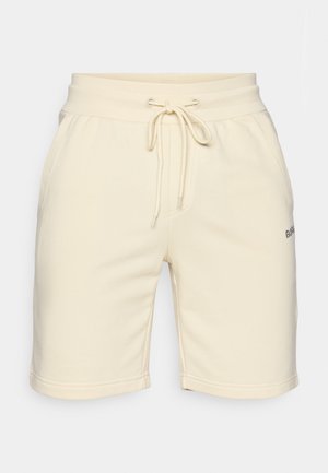 Cream-colored cotton shorts with an elasticized waistband, drawstring, side pockets, and small embroidered logo on the left hem.