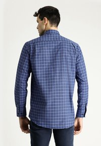 Camicia a maniche lunghe a quadri blu con colletto strutturato, caratterizzata da un motivo di quadrati blu scuro e chiaro, e polsini con bottoni.