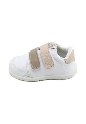 Zapato blanco para niño pequeño con doble cierre de Velcro beige y suela blanda, diseñado para facilitar el ajuste y brindar comodidad.