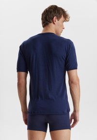Navy blue short-sleeve T-shirt, round neck, made of soft fabric. Features a relaxed fit and minimal stitching details on the edges.