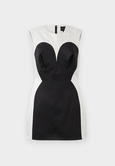 Vestido sin mangas en blanco y negro con silueta ajustada, que presenta un corsé estructurado y copas en forma de corazón, con cremallera en la parte posterior.