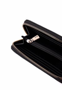 Portafoglio nero con materiale esterno testurizzato, zip dorata e più scomparti interni. Presenta una sezione con zip per lo stoccaggio.