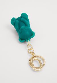Teal silicone bear keychain featuring a gold-tone keyring and clasp, with detailed facial features and rounded paws, positioned on a plain background.