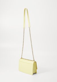 Borsa a tracolla gialla in pelle con una forma strutturata, caratterizzata da una tracolla a catena e una superficie liscia. Chiusura con un semplice design a pattina.