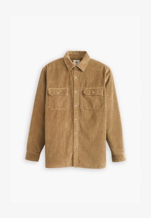 Camisa de pana en marrón claro con cuello, cierre de botones y dos bolsillos en el pecho. Presenta una tela texturizada y mangas largas.