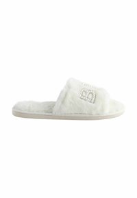 White fuzzy slide slippers with a thick sole, featuring a decorative element of small faux pearls and an outlined logo. Soft texture.