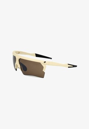 Occhiali sportivi beige e neri con lente marrone avvolgente unica e design angolare della montatura inclinata verso destra.