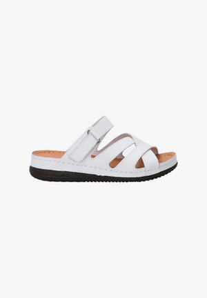 White leather slide sandal featuring wide straps with cut-out details, adjustable Velcro closure, and a textured black rubber sole.