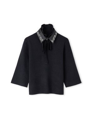 Zwarte top met driekwart mouwen, een hoge hals, een gestrikt strikje, en een zwarte kraag versierd met zilveren bloemenmotieven.