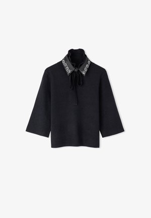 Zwarte top met driekwart mouwen, een hoge hals, een gestrikt strikje, en een zwarte kraag versierd met zilveren bloemenmotieven.