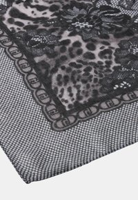 Tela negra y gris con estampado de leopardo, patrones de encaje floral y un borde de diseños en forma de cadena circular.