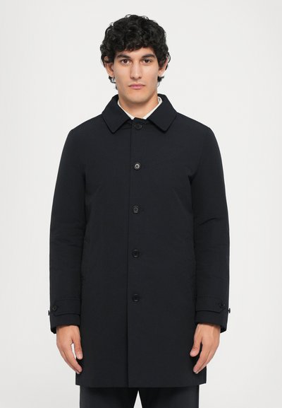 Manteau bleu marine en tissu lisse, avec un col évasé, des boutons à l'avant et des poignets boutonnés. Coupe droite avec poches latérales.