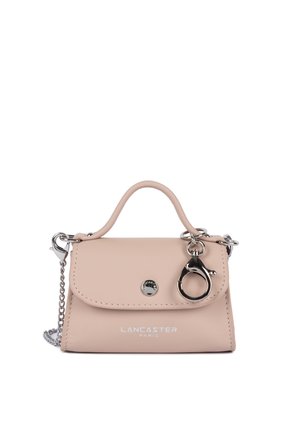 Small beige Lancaster Paris handbag with top handle, silver chain strap, front flap, and large silver lobster clasp detail.