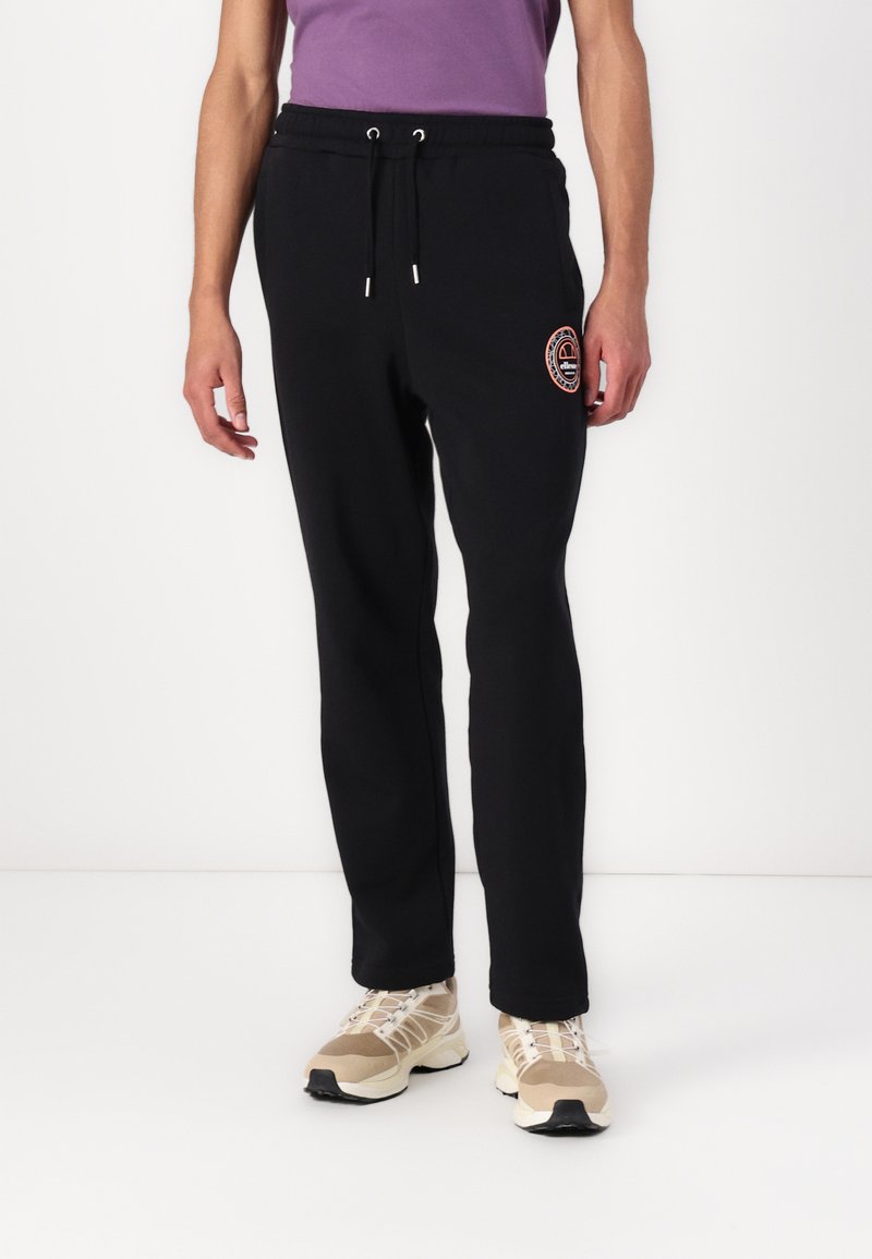 Pantalones de chándal negros con cintura ajustable mediante cordón, que cuentan con un logo bordado en naranja en el muslo y piernas ajustadas. Tejido suave de mezcla de algodón.