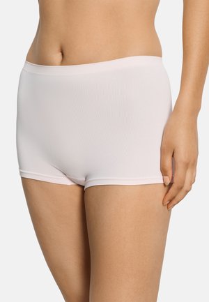 Frau trägt helle, nahtlose Boyshorts mit hoher Taille in blassrosa, dargestellt von der Taille bis zur Mitte des Oberschenkels vor neutralem Hintergrund.